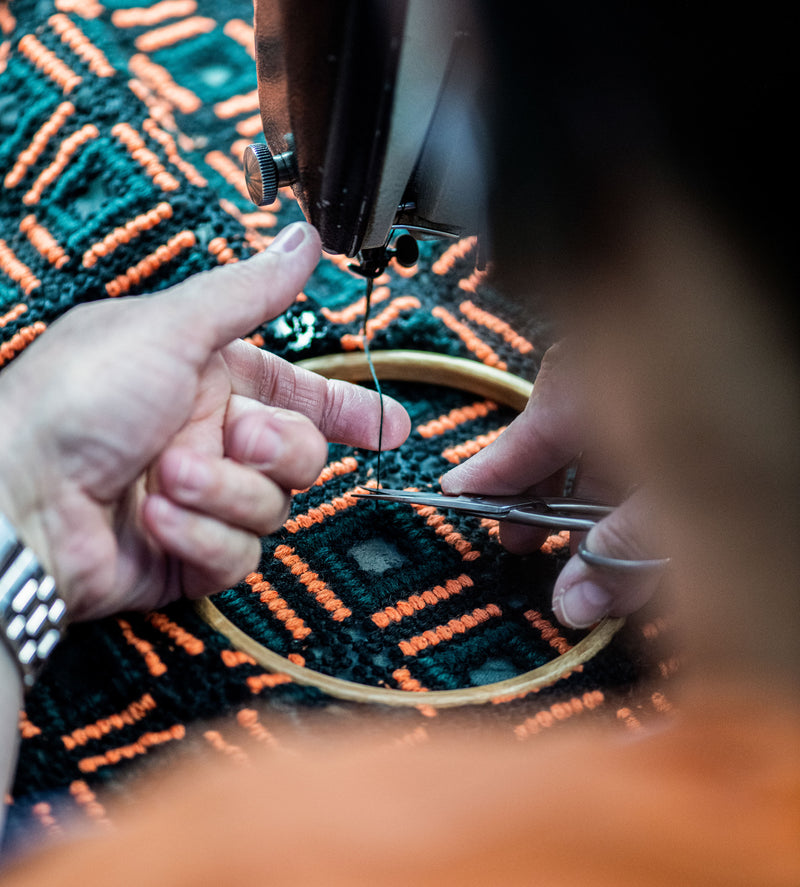 Close-up of a seamstress completing embroideries by hand.